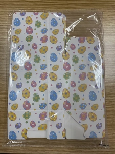 Flat lay of colorful Easter egg pattern paper candy boxes in transparent packaging
