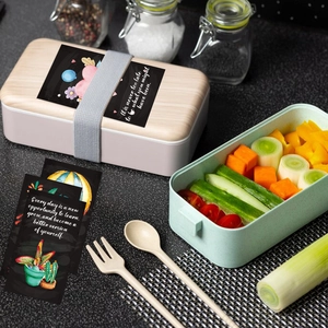 Macro view of inspirational chalkboard lunch box notes with colorful floral illustrations