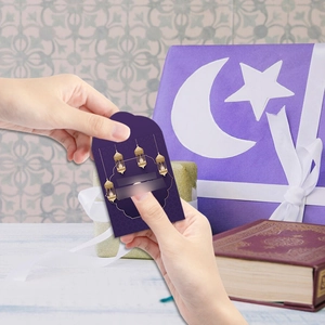 Close-up of Eid Mubarak themed purple hanging tag with gold lantern and moon patterns