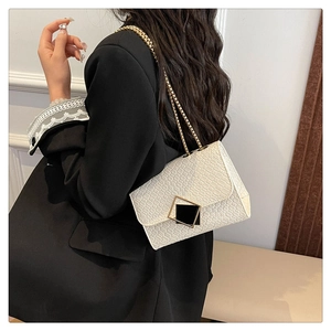 Detail view of white crocodile pattern shoulder bag with gold chain and square buckle