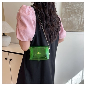 Detailweergave van een transparante smaragdgroene mini-crossbodytas gedragen door een model