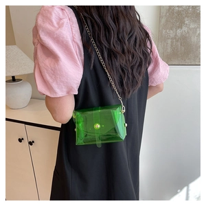 Groene transparante jelly crossbody tas met gouden ketting gedragen door een model