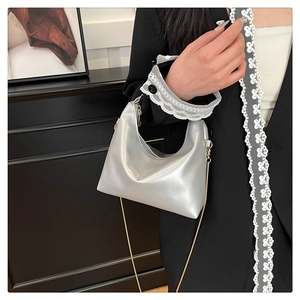 Detail of silver metallic hobo bag featuring fine gold chain and shimmering finish