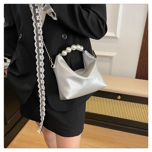 Silver metallic hobo bag with pearl handle and chain strap shown on a model