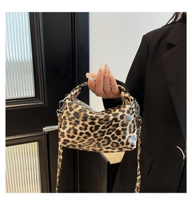 Detailed shot of leopard print handbag with wide shoulder strap and metal zipper