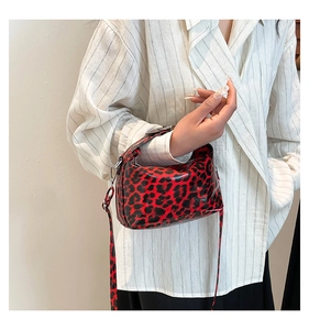 Close-up of red and black leopard print handbag in glossy patent leather finish