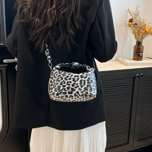 Leopard print crescent shoulder bag with silver hardware on a fashion model