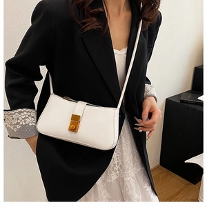 Close-up of white leather shoulder bag featuring a premium gold rectangular metal twist lock