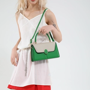 Green and beige patchwork square handbag with crossbody strap shown on model in studio