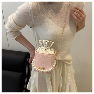 Detail of pink snakeskin pattern bucket bag with pearl handle and drawstring closure