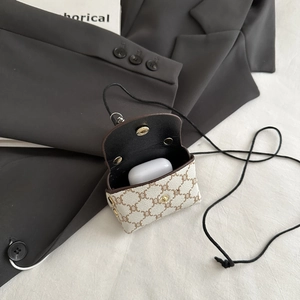 Detail view of mini monogram crossbody bag showing AirPods inside and gold button snap