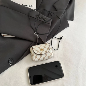 Close-up of mini monogram neck bag with gold buckle and cream vintage pattern