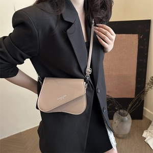 Sac bandoulière beige minimaliste avec rabat asymétrique et boucles argentées