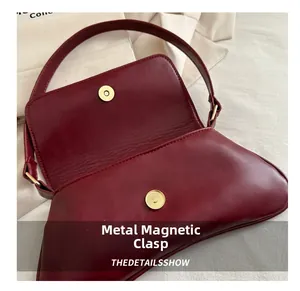Detail einer weinroten Ledertasche mit sicherem goldenem Magnetverschluss aus Metall
