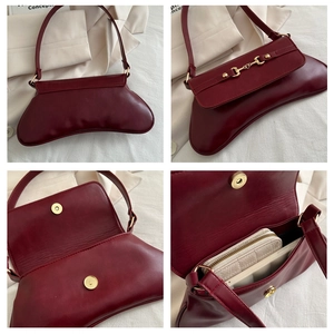 Detailansicht der weinroten Leder-Achseltasche mit goldener Trensenschnalle und Verschluss