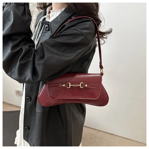 Detail der burgunderroten Baguette-Tasche mit glattem Lederfinish und goldener Trense
