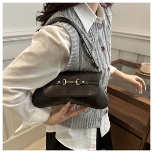 Detail der braunen Vintage Leder-Achseltasche mit goldener Schnalle und gebogenem Boden