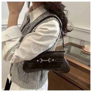 Detail der braunen Vintage-Schultertasche mit goldenem Trensen-Detail und Lederstruktur
