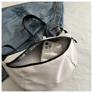Interior view showing large capacity for smartphone in off-white crescent crossbody bag
