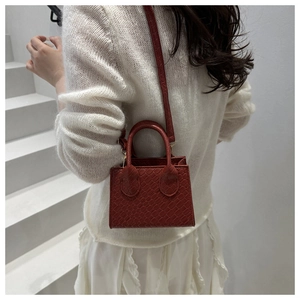 Red crocodile texture mini handbag styled with a white outfit on minimalist stairs