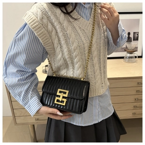 Gros plan d'un sac à bandoulière en cuir noir avec surpiqûres et boucle dorée chic