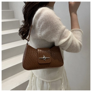 Detailed view of brown woven texture underarm bag featuring a silver star metal buckle