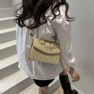 Sac bandoulière tissé d'été avec boucle nœud, porté par un mannequin sous la lumière