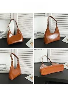 Macro view of caramel brown glossy patent leather hobo bag showing texture and stitching