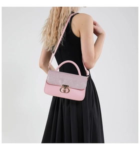 Pink sequined flap handbag with gold metal ring lock shown on black dress