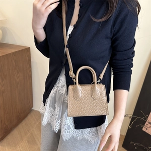 Beige woven diamond pattern crossbody bag with dual handles and slim shoulder strap