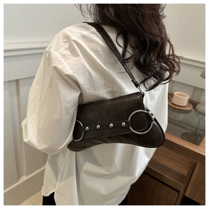 Détail du sac sous le bras marron foncé vintage avec texture plissée et anneaux argentés
