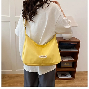 Yellow PU leather crescent hobo bag shown with an adjustable strap in a lifestyle setting