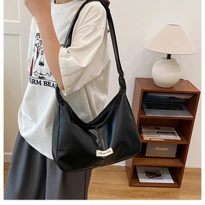 Detail of black large capacity PU leather tote bag with white fashion logo label