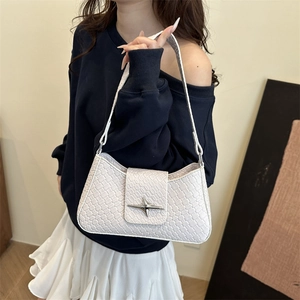 White woven leather underarm bag with a silver star buckle shown on a female model