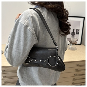 Détail du sac baguette en cuir PU noir avec grands anneaux et rivets en métal argenté