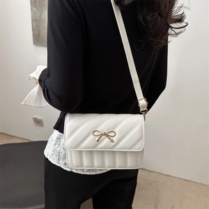 Chic white quilted shoulder bag with golden bow clasp and adjustable strap for women