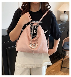 Detail des rosa Mode-Rucksacks mit dekorativer Perlenkette und silbernen Schleifen