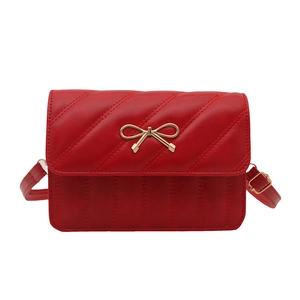 Sac bandoulière rouge vintage avec motif matelassé et boucle nœud dorée sur blanc
