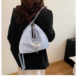 Detail der hellblauen Hobo-Tasche mit mattem Wildlederimitat und Perlenkette
