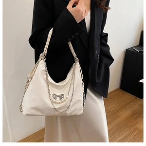 Detail der Hobo-Tasche mit silbernem Schmetterling, Perlen und metallischer Kette