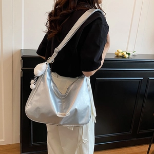 Silver metallic large tote bag with plush ball charm and fashion label for women