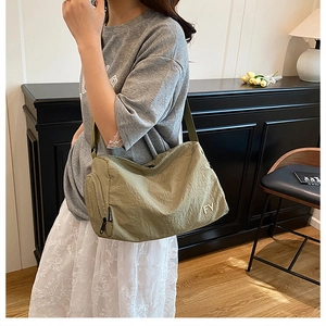 Détail du sac messager en nylon vert armée montrant sa texture et sa bandoulière réglable