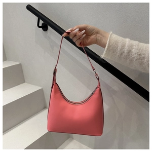 Detail of pink hobo bag featuring matte leather texture and silver buckle adjustment