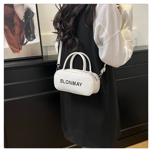 Detail of white cylinder baguette bag with woven texture and black brand logo