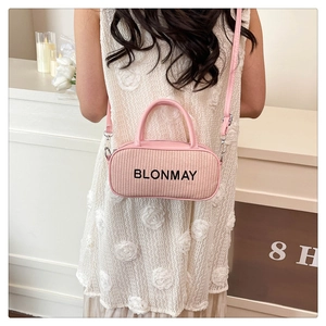 Detailed shot of pink woven mini bag with black embroidery and pink leather strap