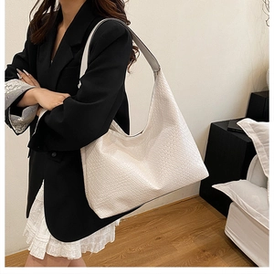 Close-up of white woven leather texture on a large capacity hobo shoulder bag for women