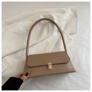 Detail of light brown woven texture shoulder bag with gold square buckle and flap closure
