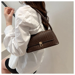 Detail of dark brown crossbody bag featuring woven texture and golden square lock
