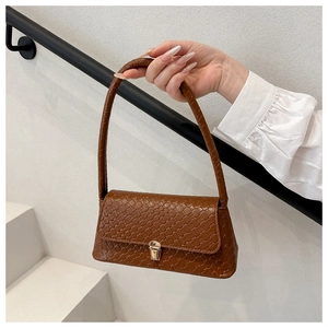 Close-up of a dark brown woven leather shoulder bag with a gold metallic clasp detail