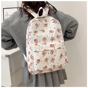 Detail of white backpack with festive cartoon bear print and secure zipper compartments